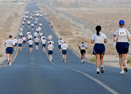group of people jogging on gray road