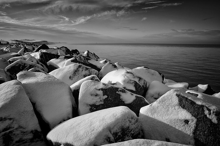 Winter time scene of some snow-covered rocks. Image captured on the coast of Kent, England