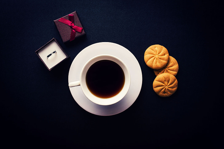 Overhead shot of coffee, biscuits and a ring