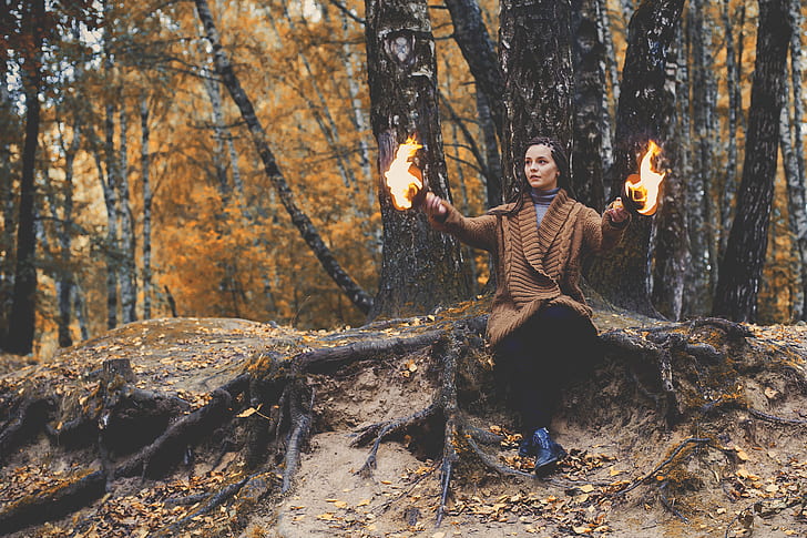 girl playing with fire in forest