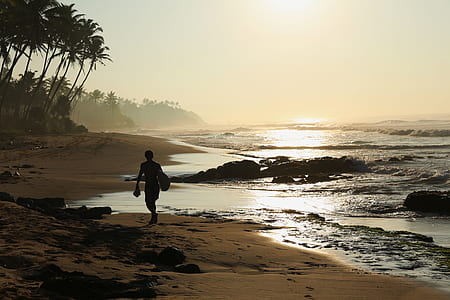male surfer walking on seashore