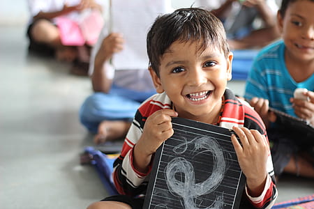boy holding a black board smiling