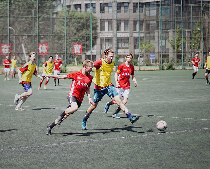players playing soccer during daytime