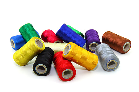 photograph of assorted-color thread spool lot