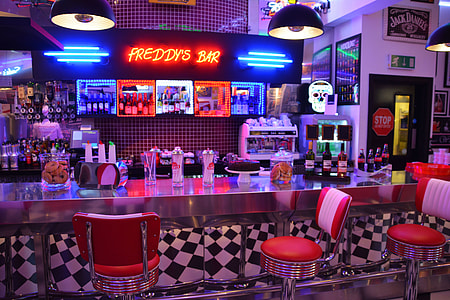 Freddy's Bar with neon lights turned on and red stools
