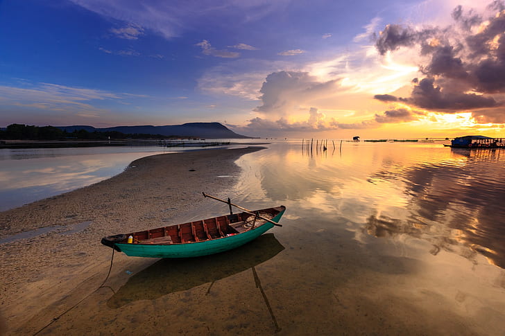green and brown boat on seashore during golden hour