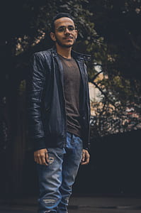 Man in Brown Shirt and Black Leather Zip-up Jacket and Blue Denim Pants