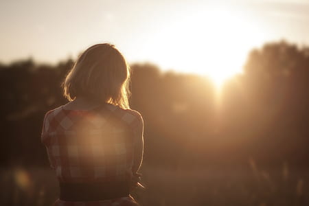 woman in red and white checkered shirt standing during sun rise