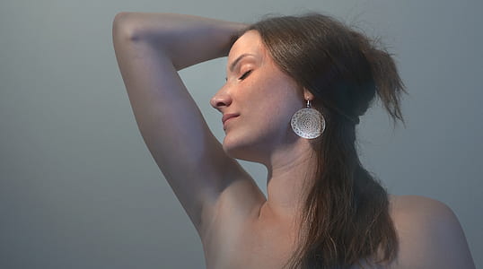 woman wearing silver-colored dangling earring