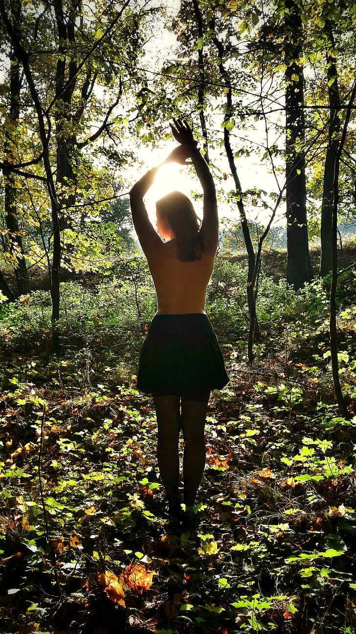 women's black skirt standing inside the forest