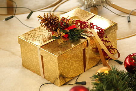 gold-colored floral gift box on beige surface