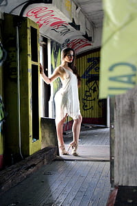 woman wearing white tank dress and brown stilettos near door