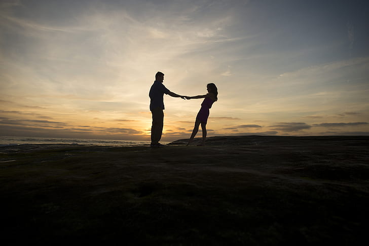 silhouette of man and woman standing facing each other