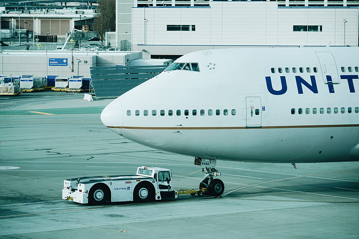 close up photograph of white airplane beside white vehicle during daytime