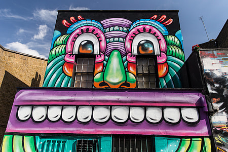 A building covered in colourful street art resides on the streets of Camden, Central London