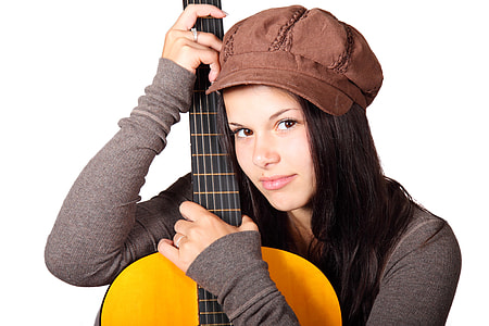 woman wearing gray long-sleeved shirt and brown cap holding brown guitar
