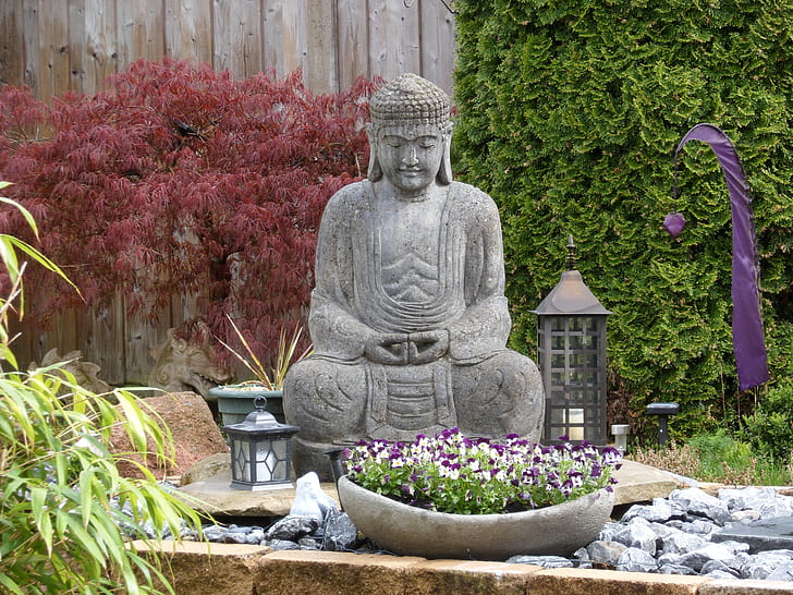 Gautama Buddha statue surrounded of plants