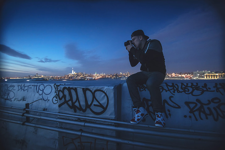 A man takes a photo at night in New York