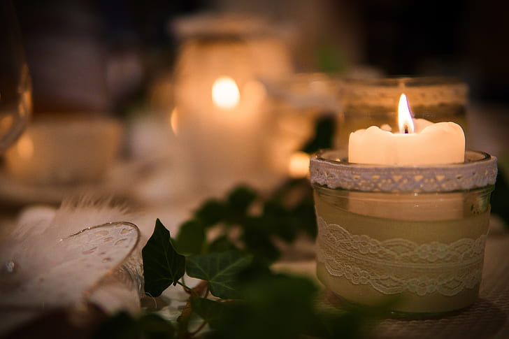 lighted white tealight candle in closeup photography