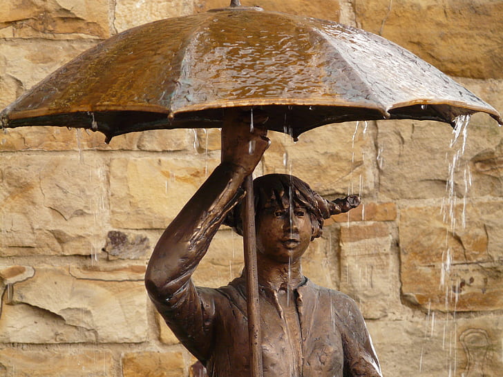 man holding umbrella statuette