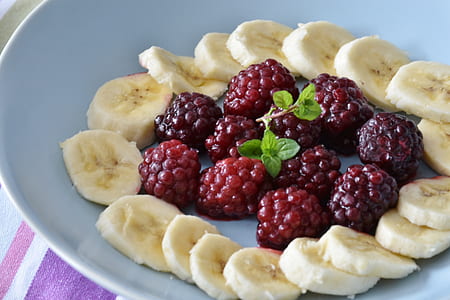 bunch of grapes and sliced banana serve on white ceramic plate