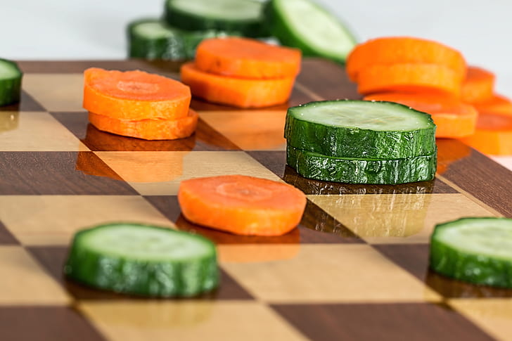sliced cucumber and carrots on brown chess board