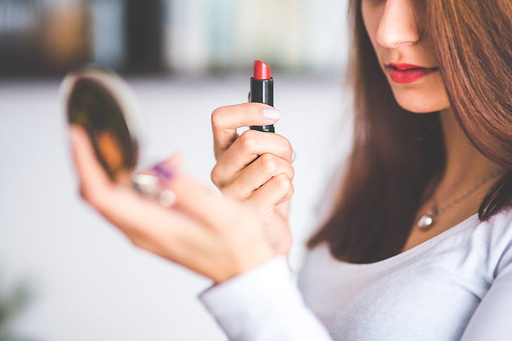 woman holding red lipstick