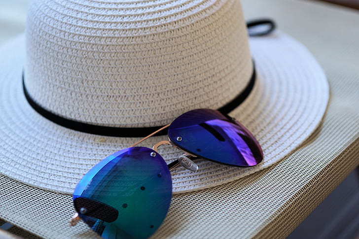 purple sunglasses beside white strawhat