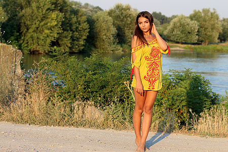 woman wearing yellow and red floral mini dress near the lake