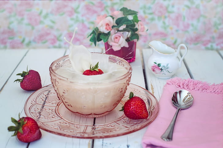 pink bowl filled with white cream and strawberry