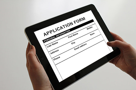 person holding tablet displaying application form