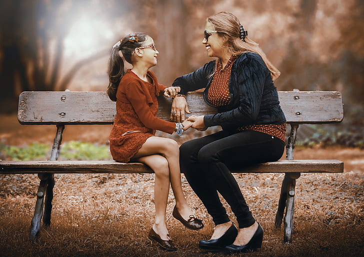 mother and daughter sitting on the bench