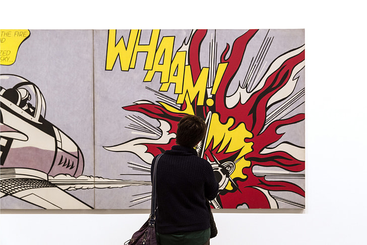 A person looks at pop art by Roy Lichtenstein in an art gallery in London, England