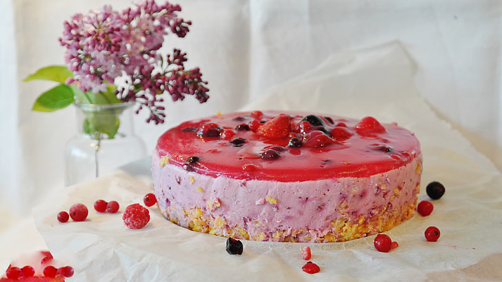 strawberry cake with cherry toppings on white tray