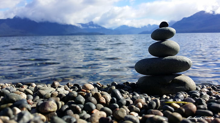 closeup photo of balance stones near body of water
