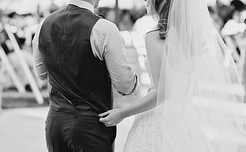 grayscale photography of couple in wedding dress and suit