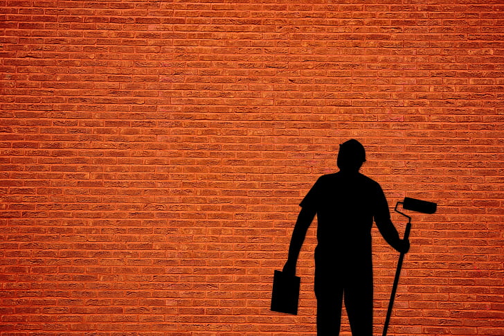 silhouette of a man holding paint roller