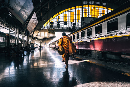 woman wearing yellow dupatta scarf walking on train station during daytime