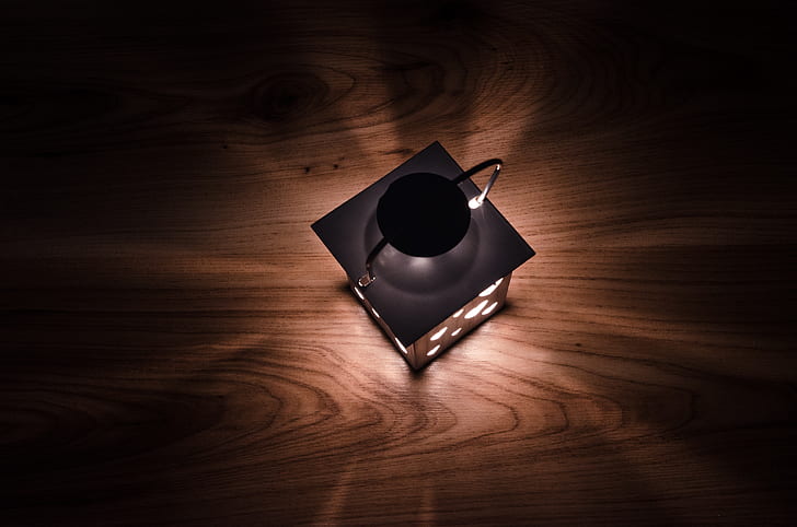 gray lantern on brown wooden surface