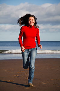 woman running near sea at daytime