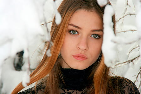 woman in black lace turtleneck top standing near white snow-covered tree