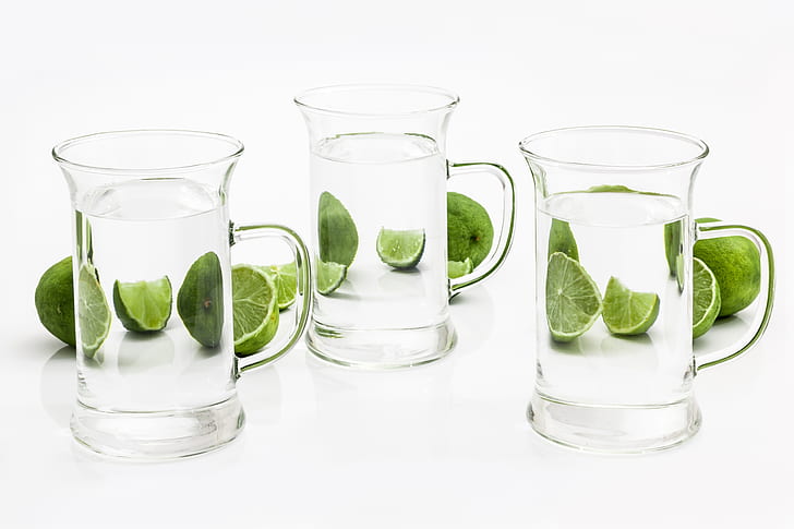 three clear glass mugs and slice lime fruit