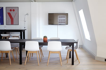 rectangular black wooden dining table and white chairs