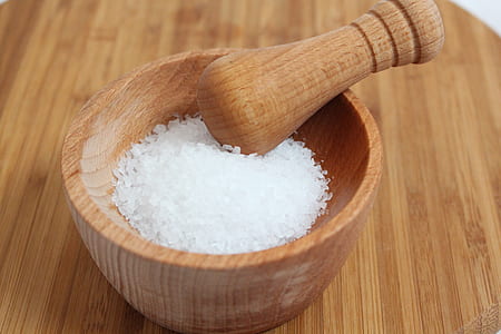 white salt on brown wooden mortar and pestle