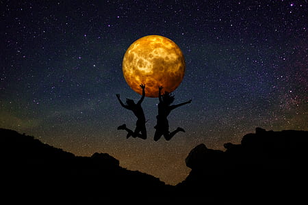 two silhouette persons jumping on cliff with moon background