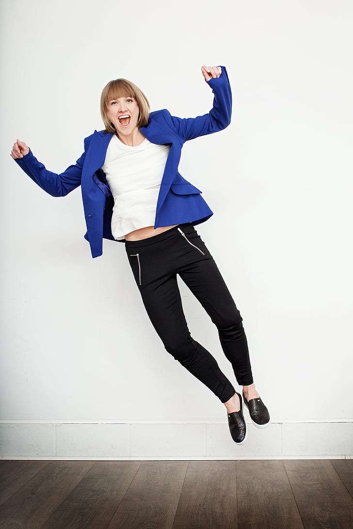 woman jump wearing blue peaked lapel suit jacket and black pants