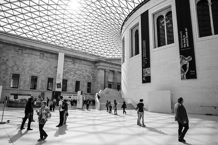 Black and white shot of people enjoying some time in the British Museum in London. This image was captured in the Great Court, this courtyard area was created by Foster and Partners architects back in the year 2000. The result is a two-acre public space with a wonderful glass roof that is recognised as the largest covered public square in Europe