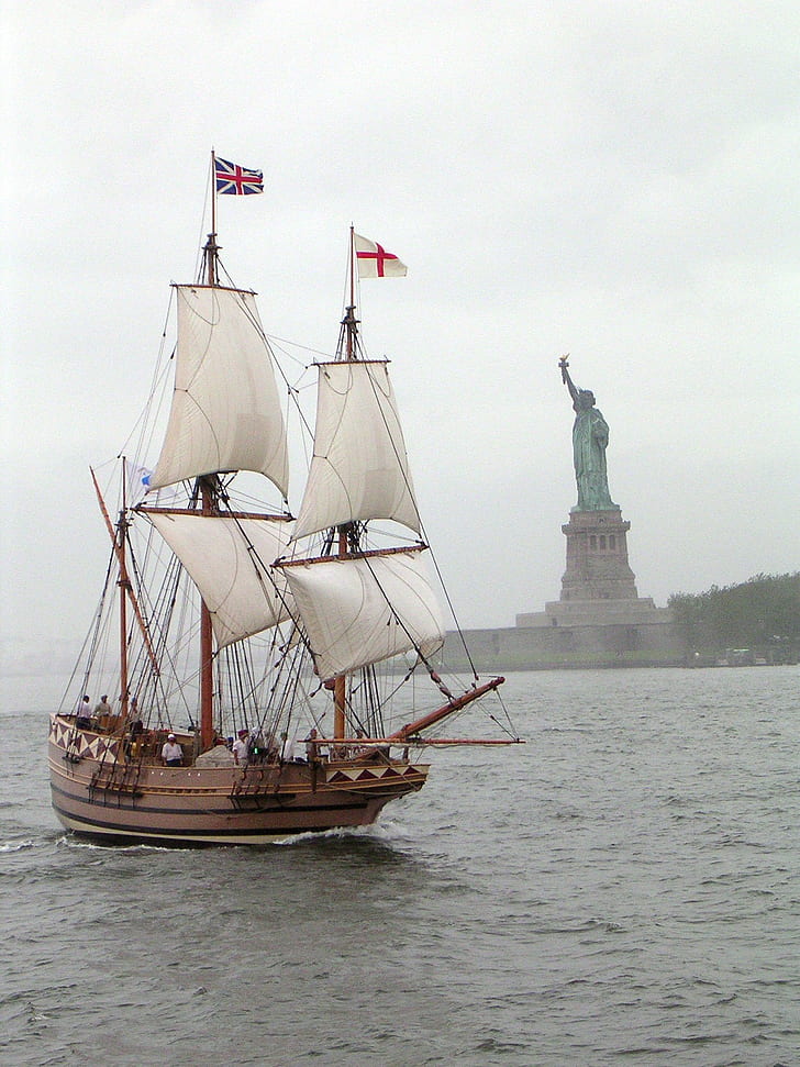 sail ship sailing near Statue of Liberty