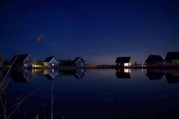 six wooden houses near body of water during night time photo