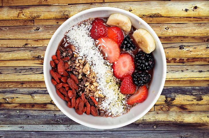 bowl of berries with banana and nuts